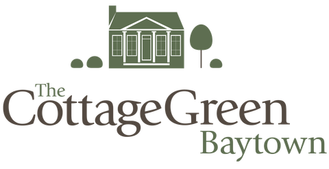 A logo for the cottage green baytown with a house and trees