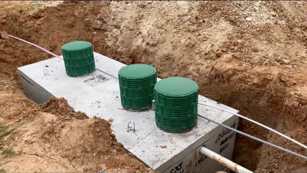 A septic tank is being built in a hole in the ground.