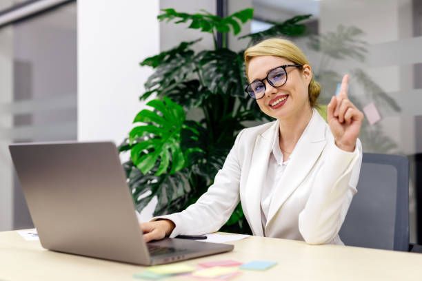 Duas mulheres estão sentadas à mesa olhando para um tablet.