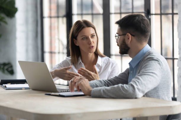 Um homem e uma mulher estão sentados à mesa conversando.