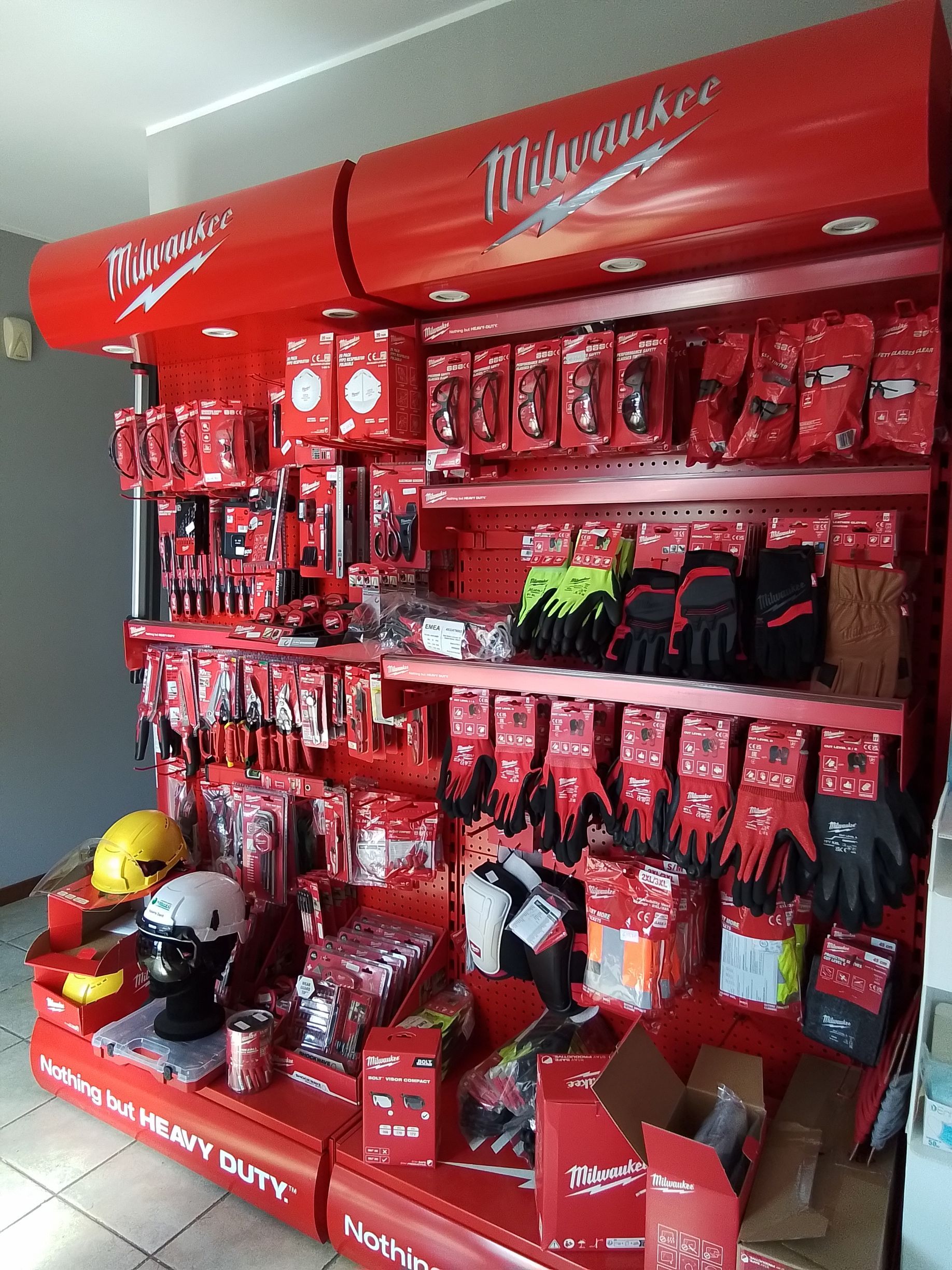 Esposizione di utensili e accessori Milwaukee rossi in un negozio.