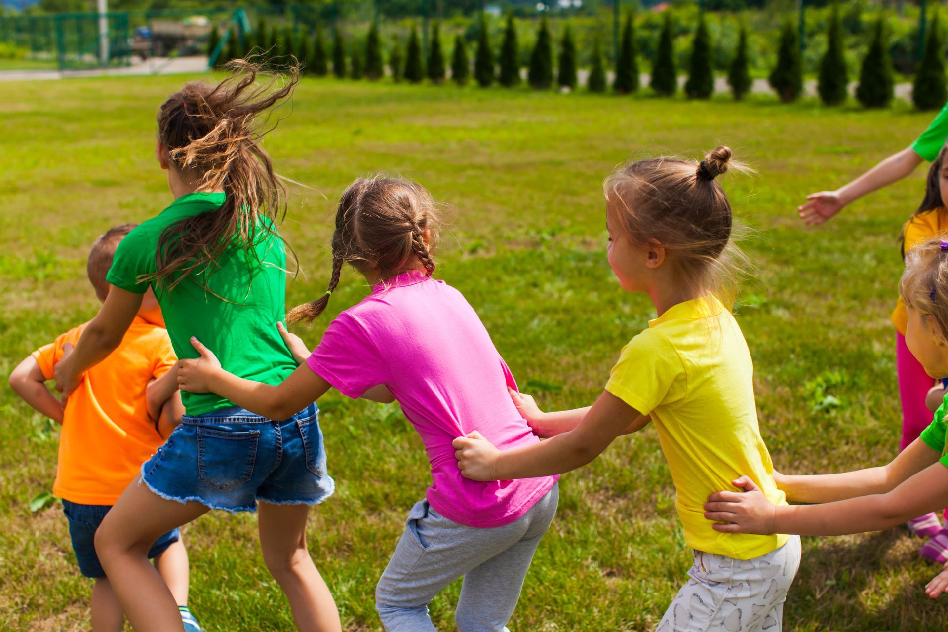 A group of children playing a game outdoors.