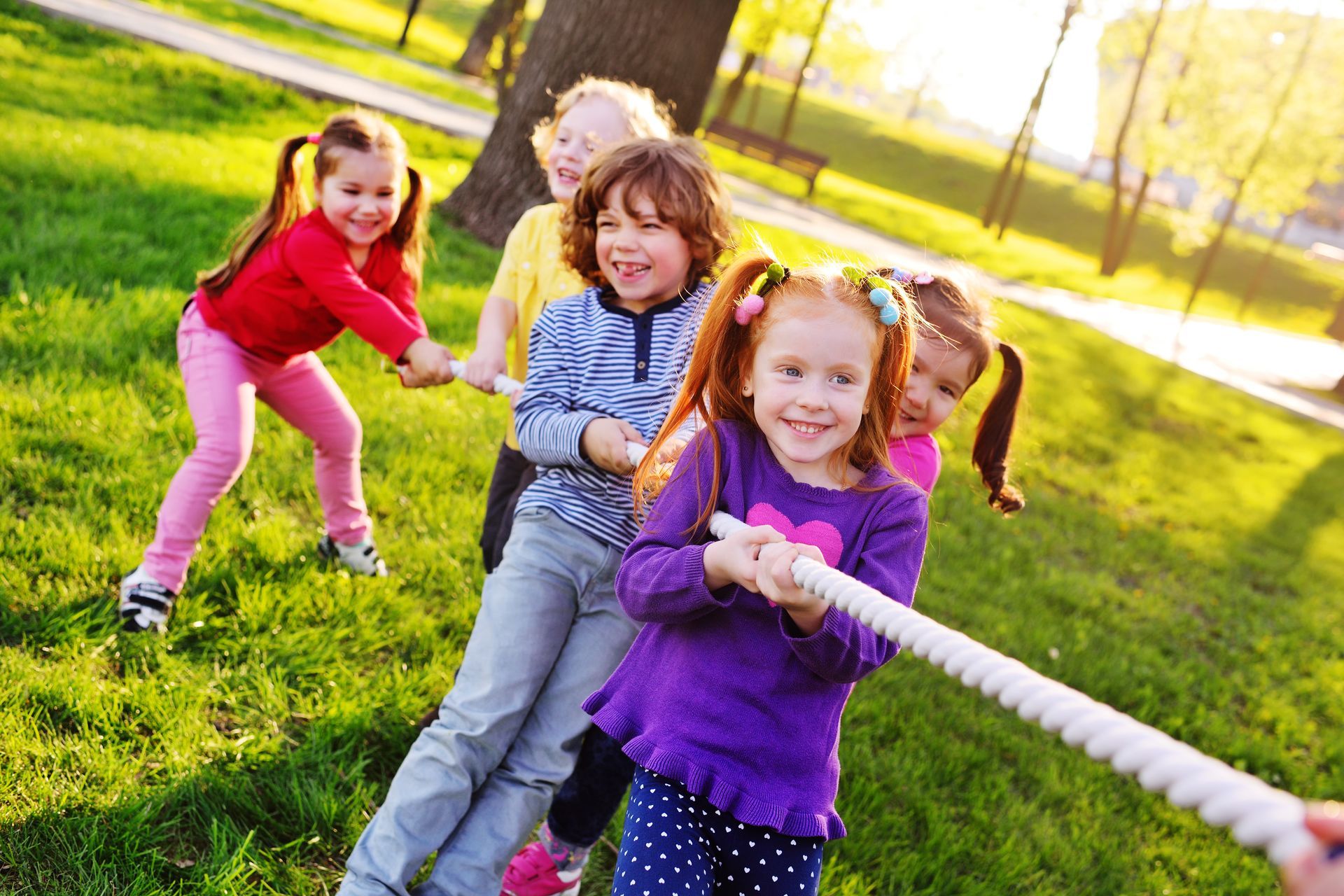 Children play tug-of-war in the park. Children play tug-of-war in the park.