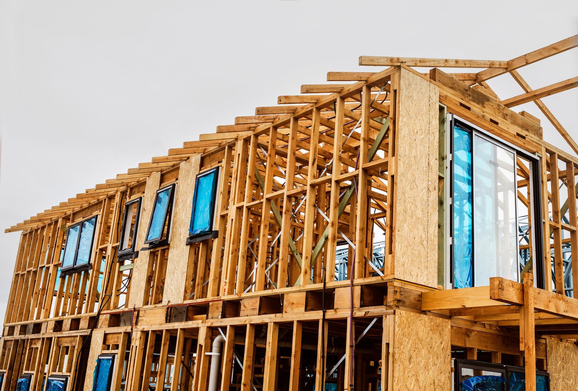 Wooden house frame under construction with windows installed.