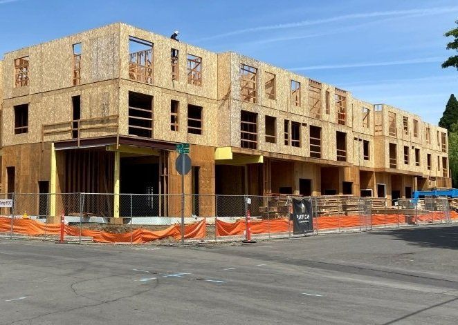 A large building under construction with a fence around it
