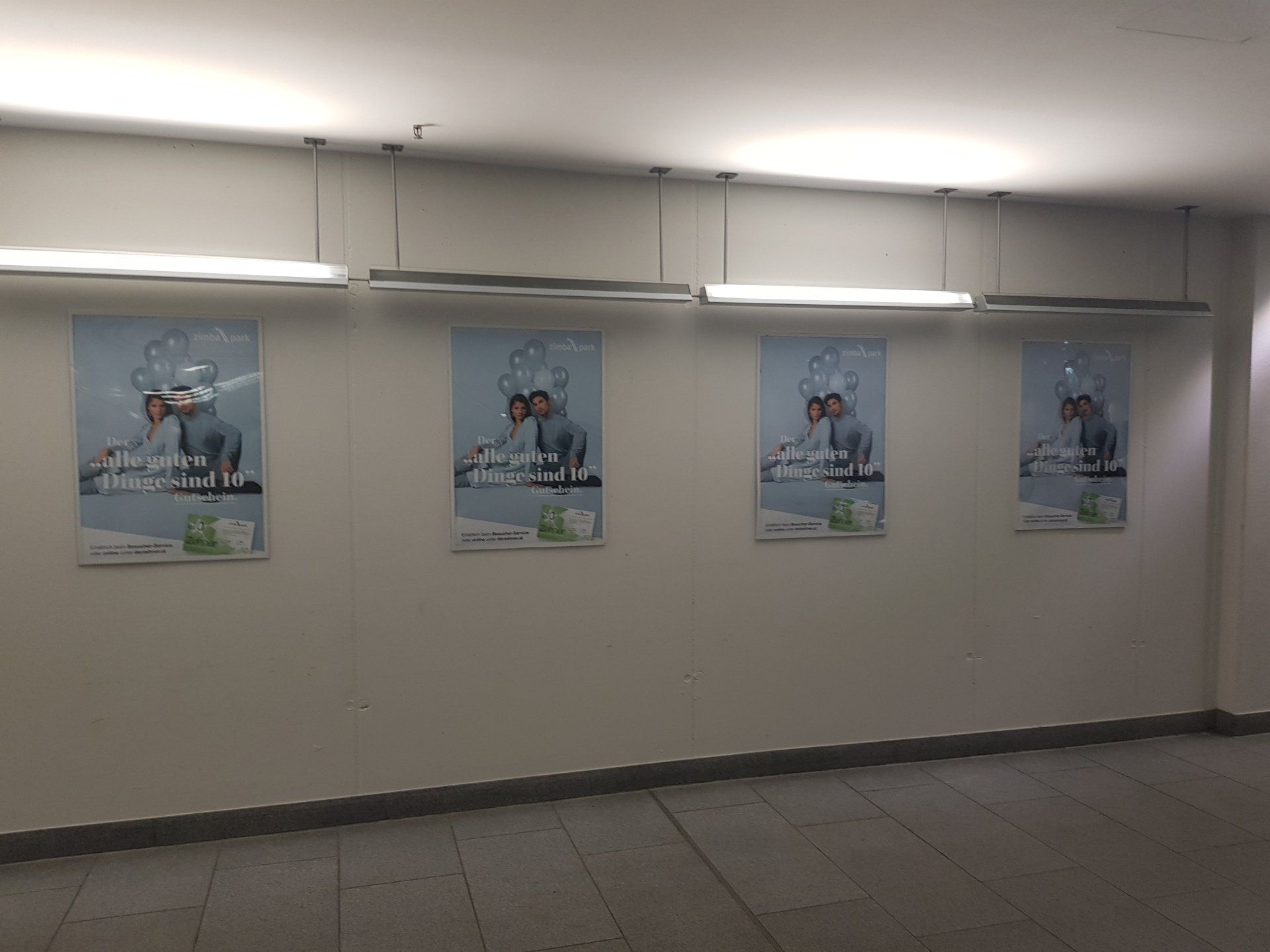 Betonwand mit gerahmten Plakaten