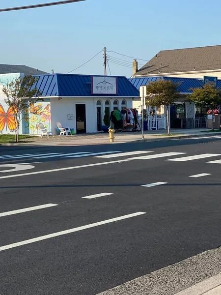 A small, white storefront with a blue roof, 