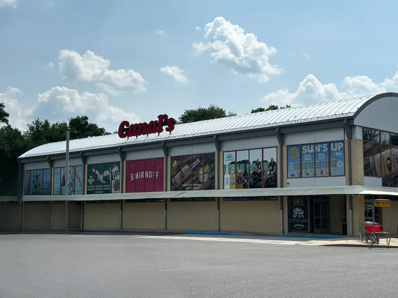 Cane's restaurant exterior with signs for different businesses against a blue sky.
