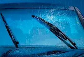 Limpiaparabrisas limpiando el agua de lluvia del parabrisas de un automóvil.