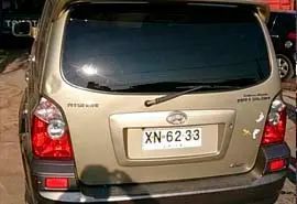 Vista trasera de un Hyundai Torra dorado con matrícula XN-62-33, estacionado al aire libre.