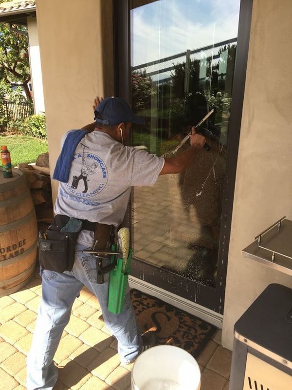 A man is cleaning a glass door with a squeegee.