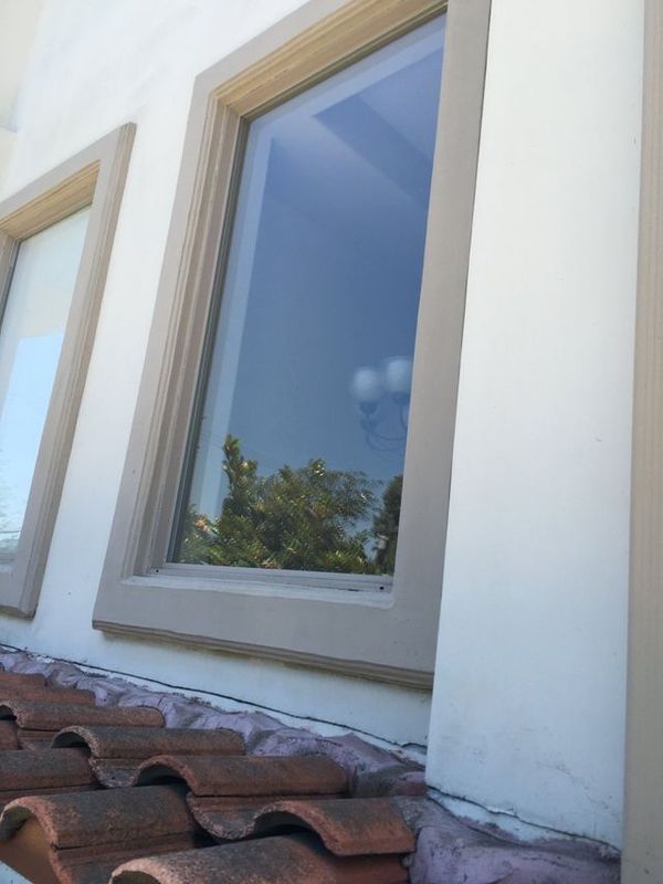 A white building with two windows and a tiled roof