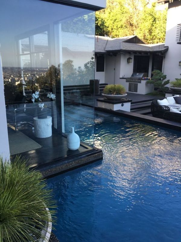 A large swimming pool is surrounded by a glass wall