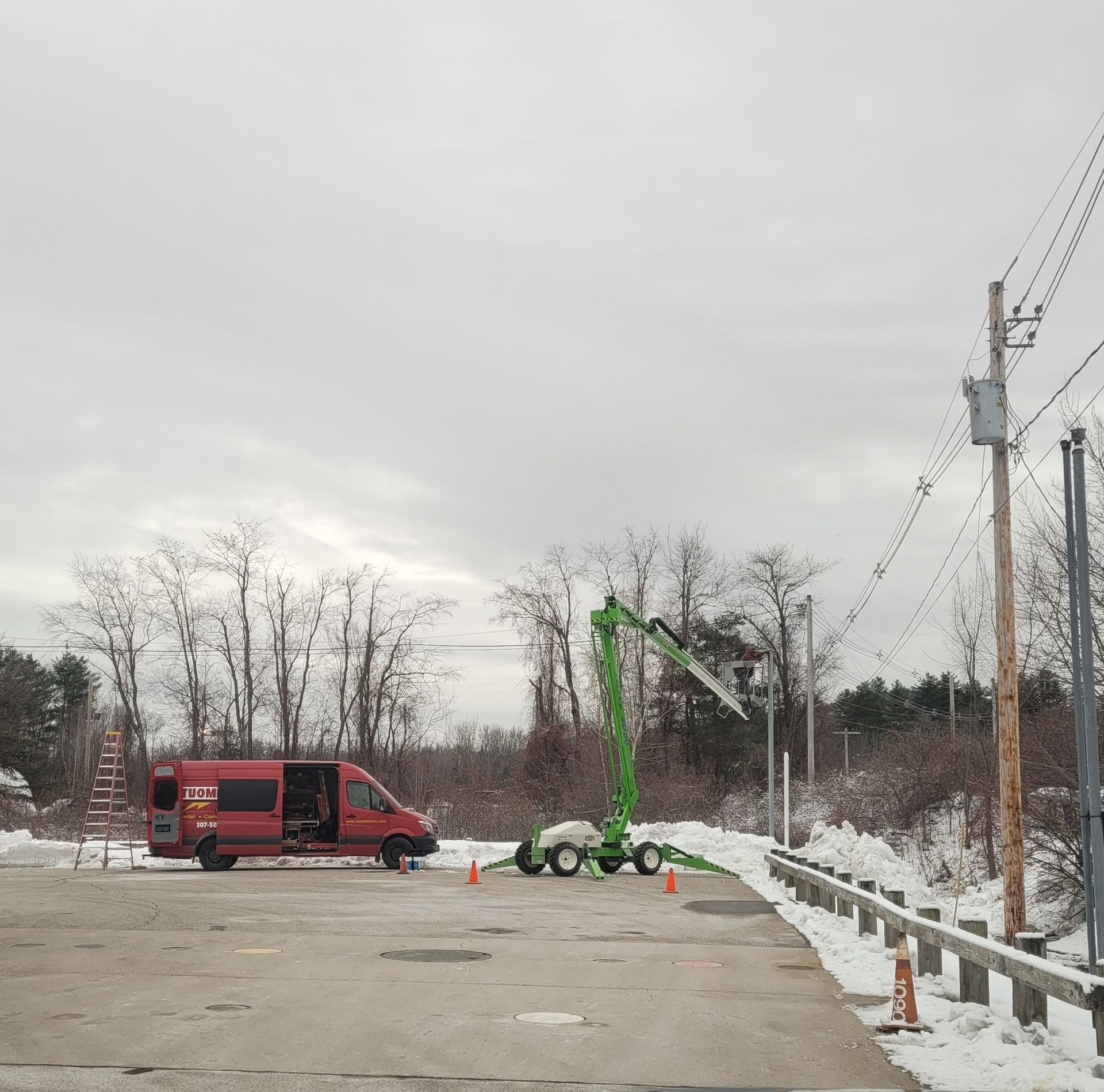 A red van is parked in a snowy parking lot