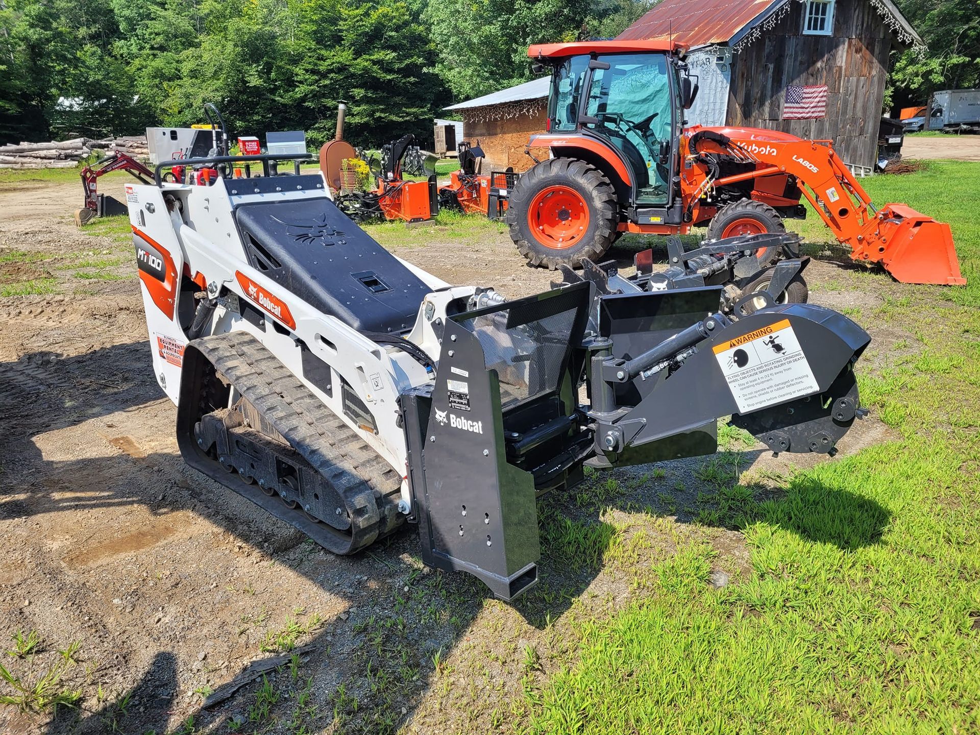 A tractor and a bulldozer are parked next to each other in a field.