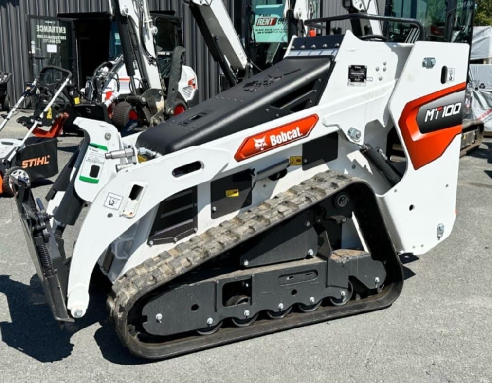 A bobcat track loader is parked on the side of the road.