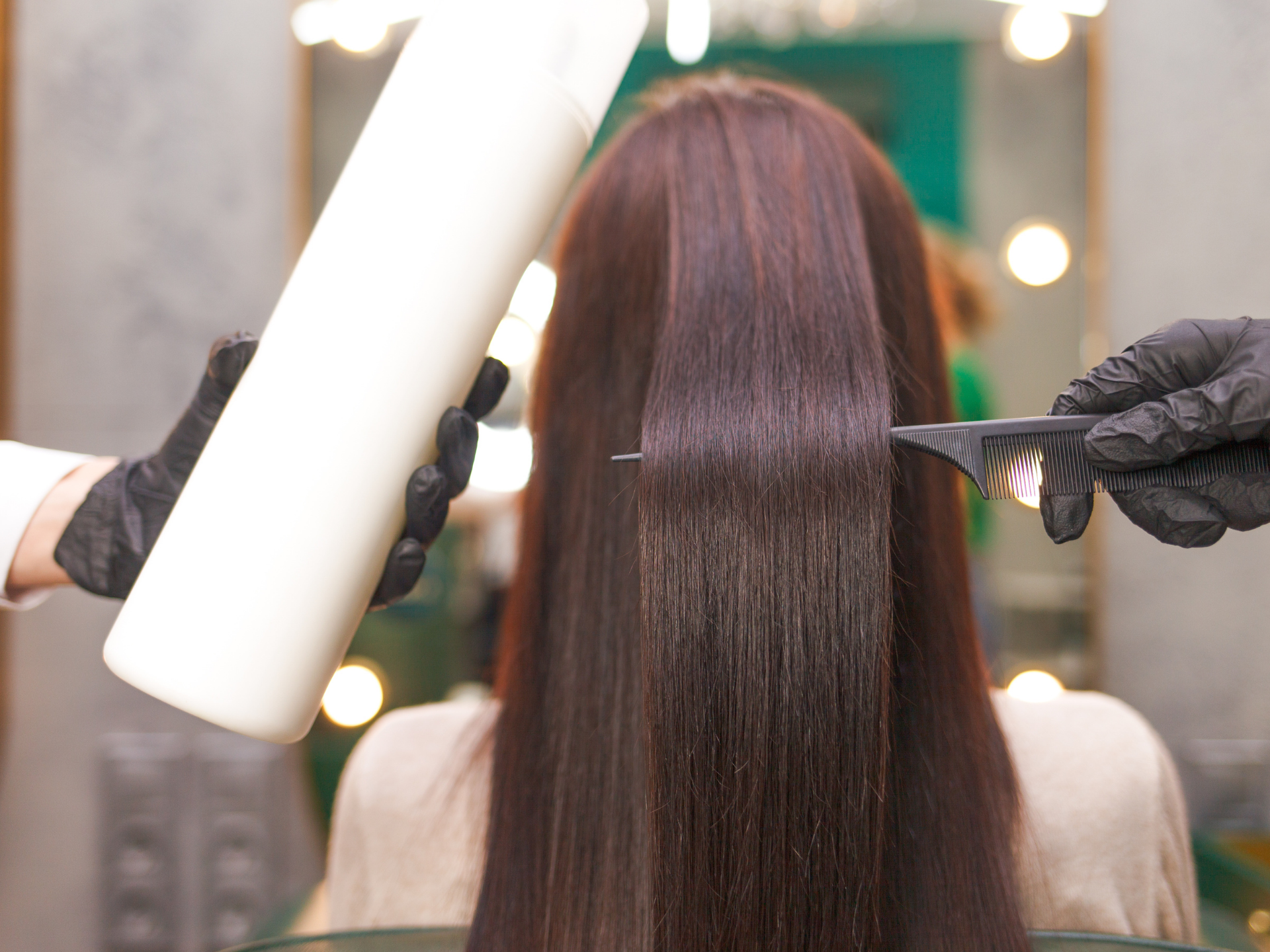 Hair being treated with a chemical straightening process in a salon.