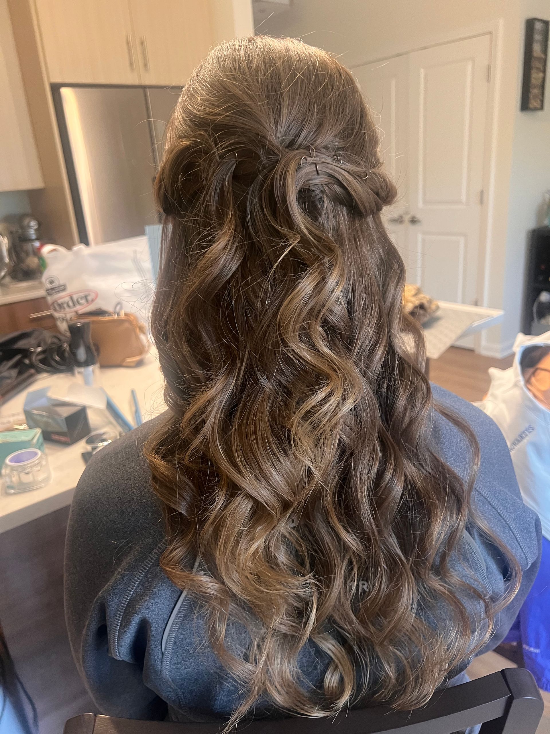 Two women in formal gowns pose outdoors, one fanning herself.