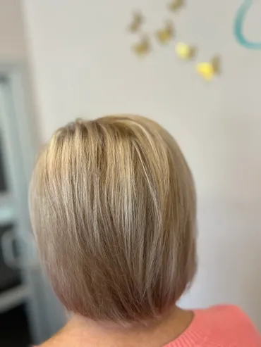 Blonde bob haircut, back view. Hair is light, with highlights, styled in a smooth, angled cut.