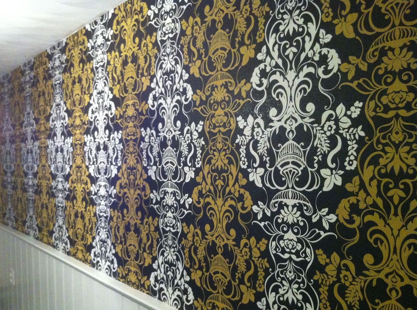 Een muur met een zwart en goud patroon erop