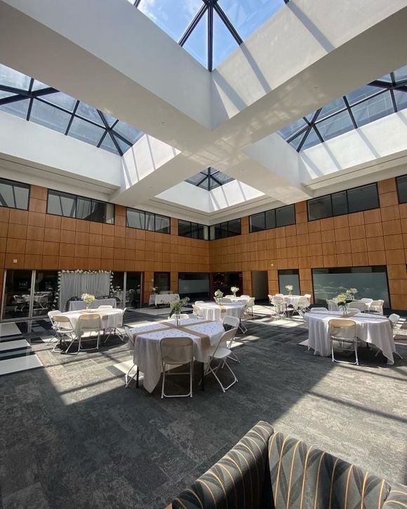 a large room with tables and chairs in it and a skylight .