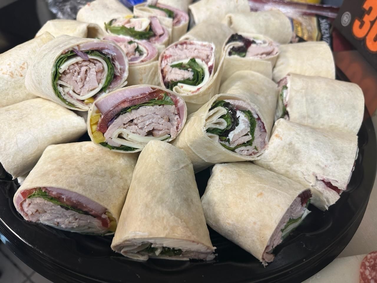 a tray of wraps with meat and vegetables on a table .