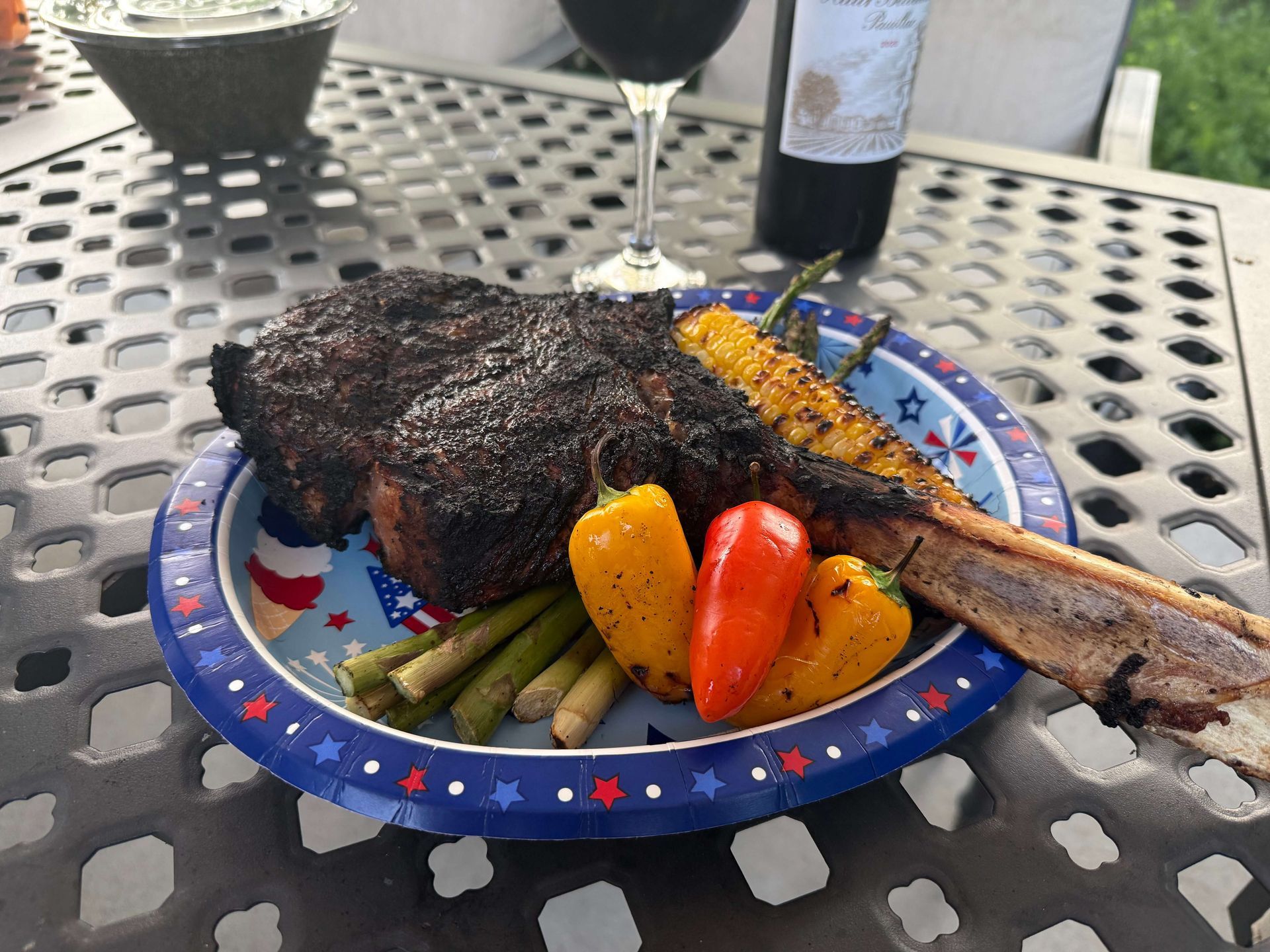 A plate of food on a table with a glass of wine.