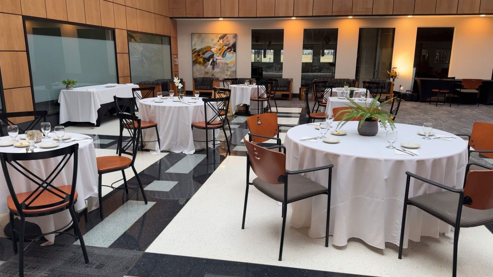 A restaurant with tables and chairs set up for a meal.