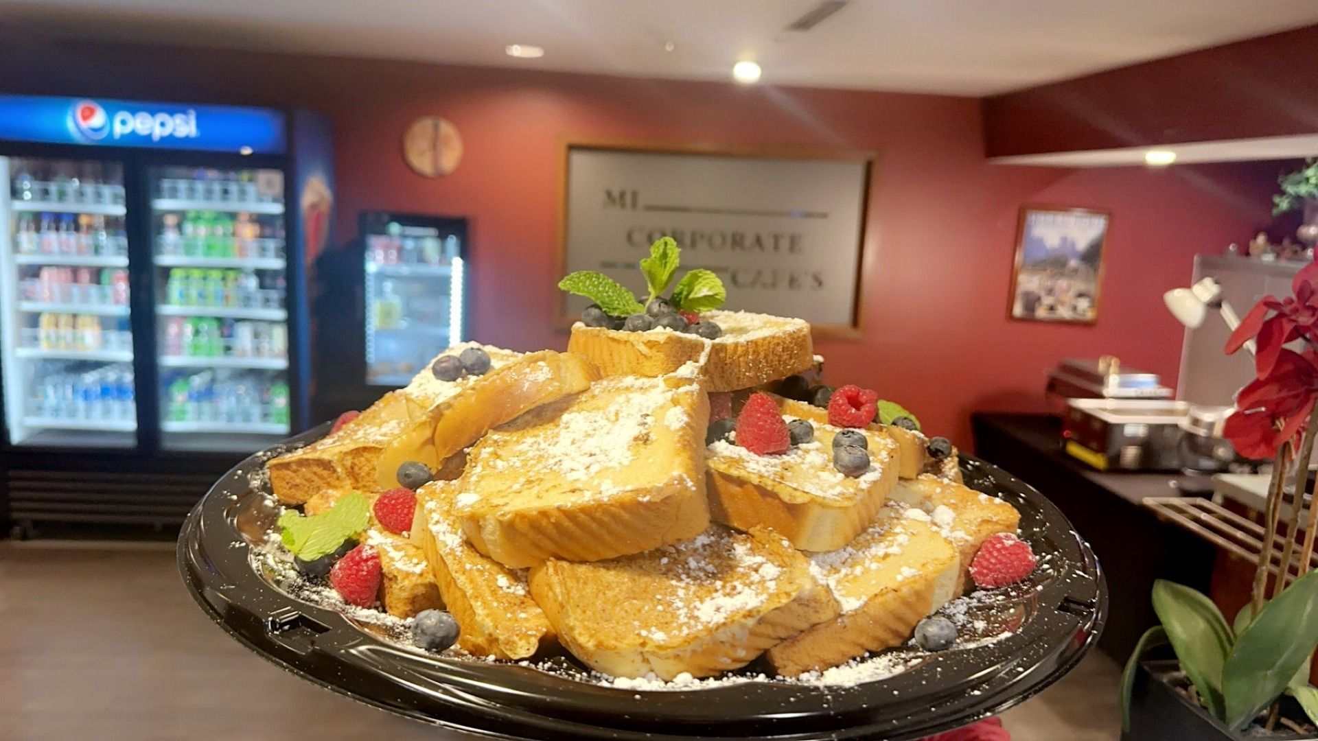 a plate of french toast with powdered sugar and berries