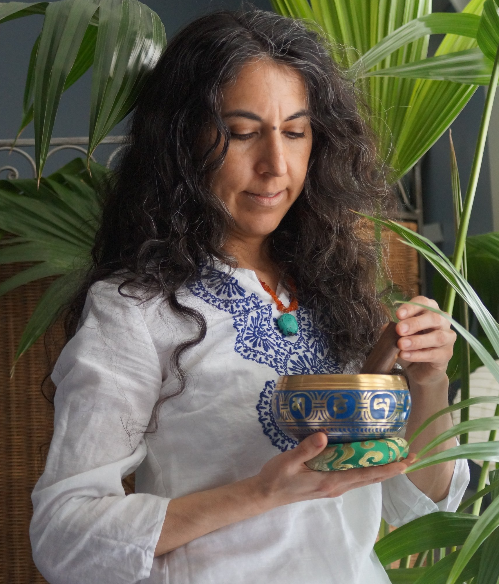 A woman in a white shirt is holding a bowl in her hands.