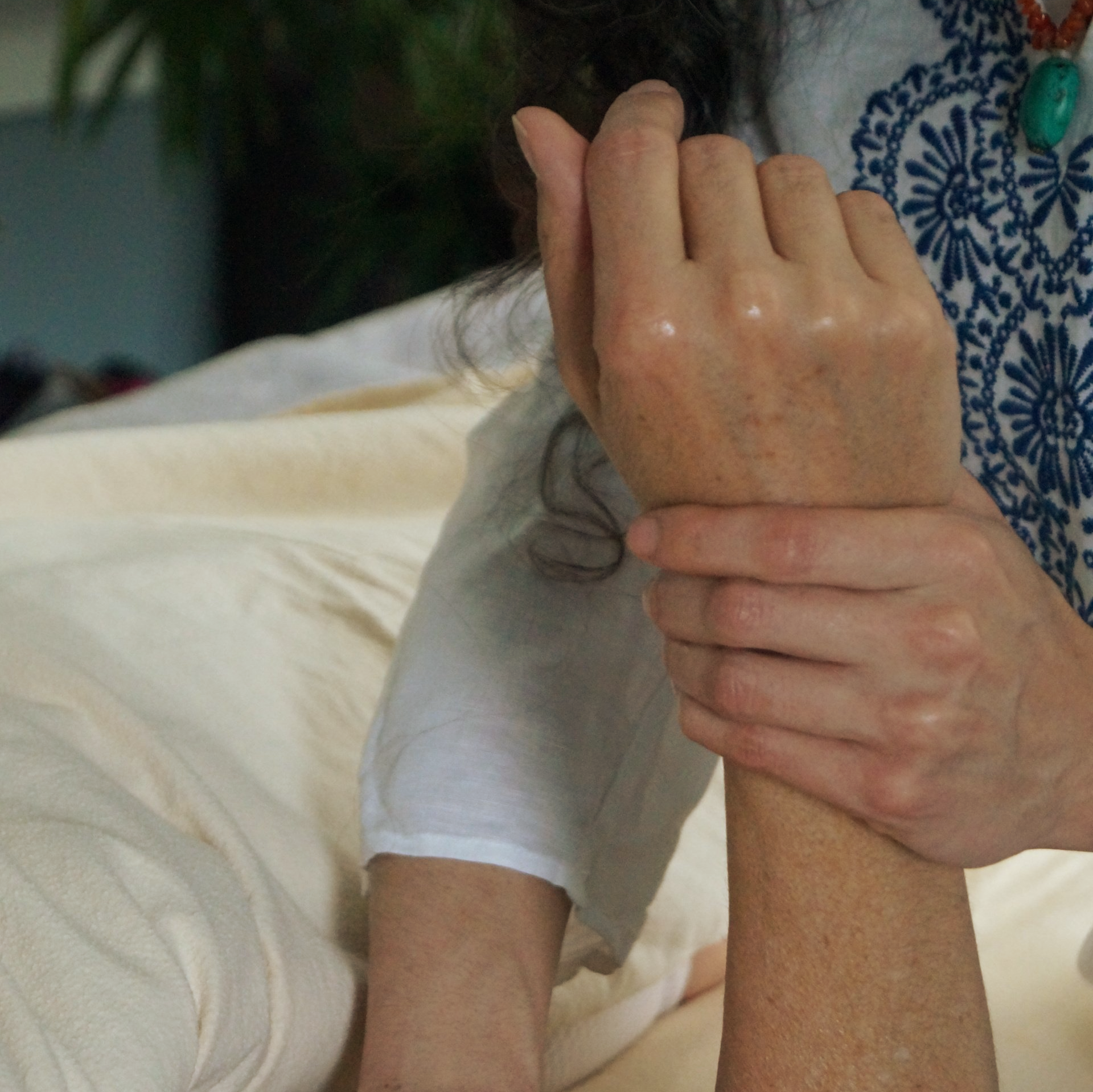 A person is holding another person 's wrist with their hands