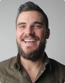 A man with a beard is smiling for the camera