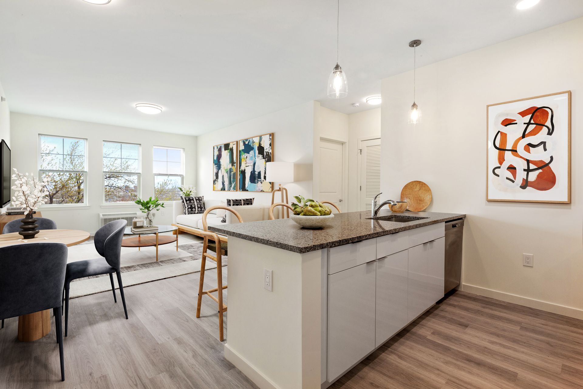 a kitchen and dining room in a house with a painting on the wall .