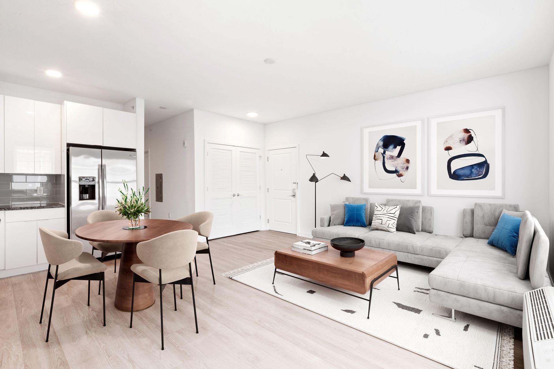 a living room with a couch , table , chairs and a refrigerator .
