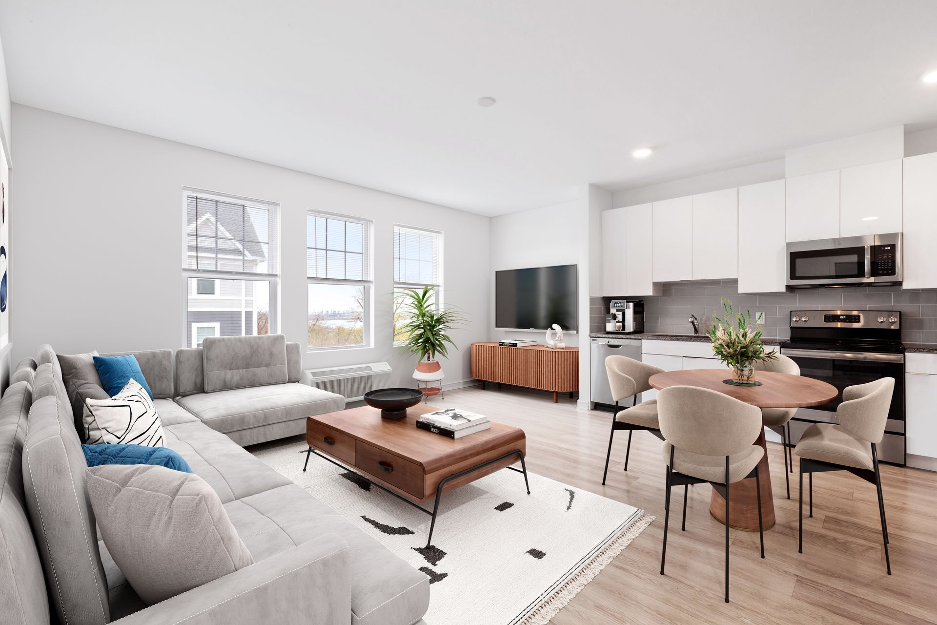a living room with a couch , table , chairs and a kitchen .