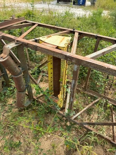 A large metal structure is sitting in the middle of a field.