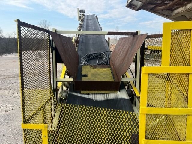 A conveyor belt with a yellow fence around it