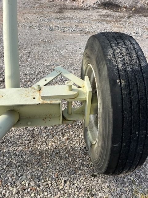 A close up of a tire on a vehicle on gravel