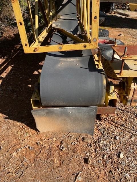 A conveyor belt is sitting on top of a pile of dirt