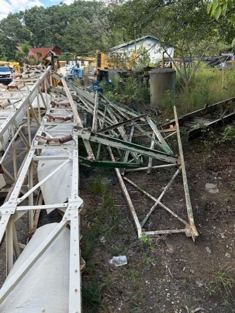 A bunch of metal pieces are laying on the ground in a field.