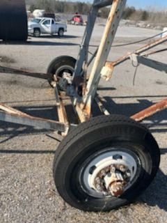 A close up of a tire on a trailer in a parking lot.