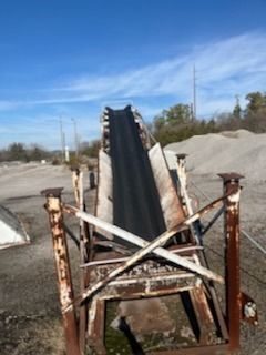 A conveyor belt is sitting on top of a rusty metal structure.