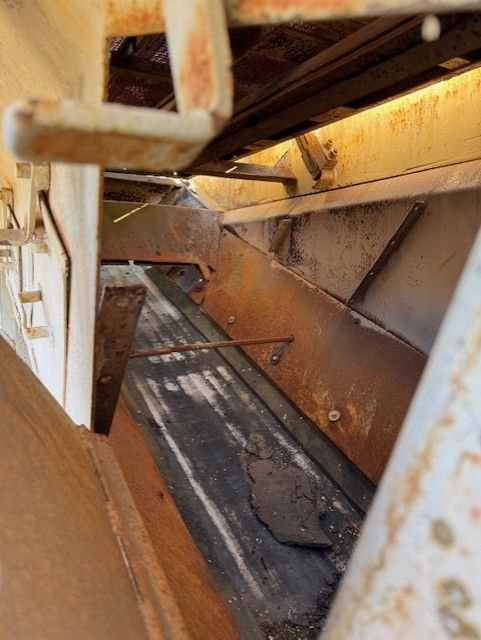 A close up of a rusty metal structure in a building.