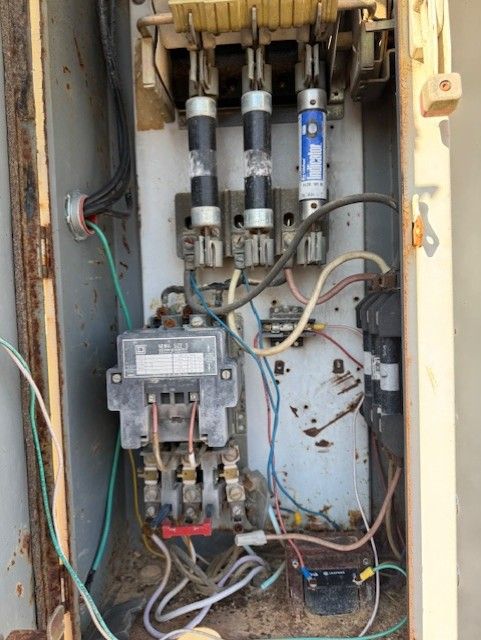 The inside of an old electrical box with wires coming out of it