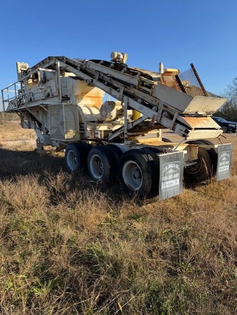 A large machine is sitting in the middle of a field.
