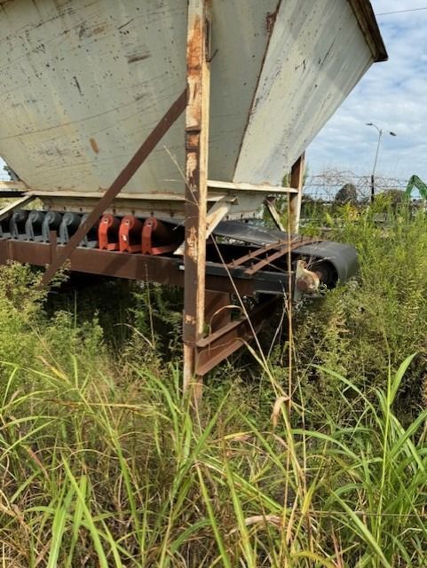 A large white container is sitting in the middle of a grassy field