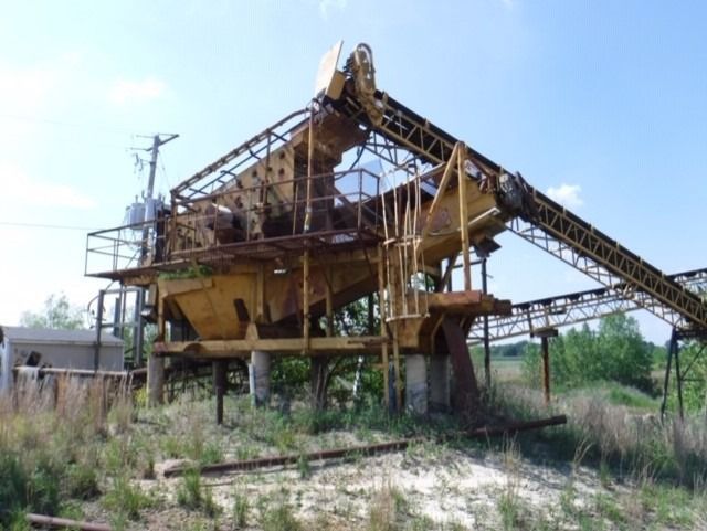 A large machine is sitting in the middle of a field.