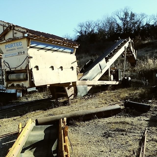 A large portec machine is sitting in the dirt