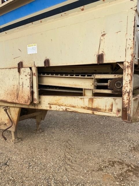 A large piece of metal is sitting on a gravel road