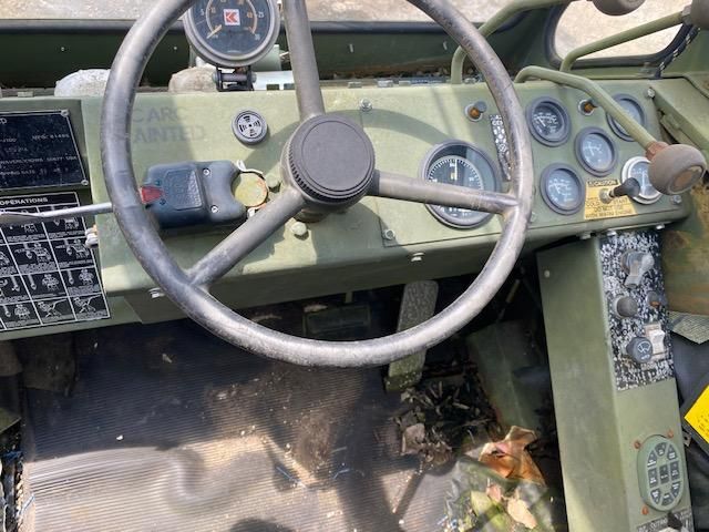The interior of a military vehicle with a steering wheel and dashboard.